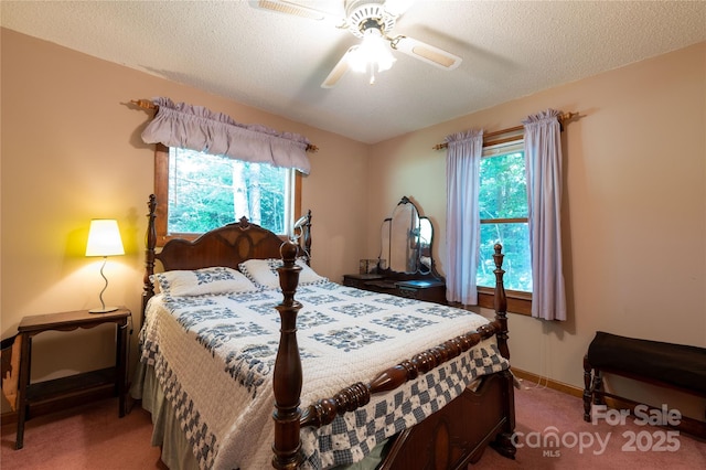 bedroom with a textured ceiling, carpet flooring, and ceiling fan