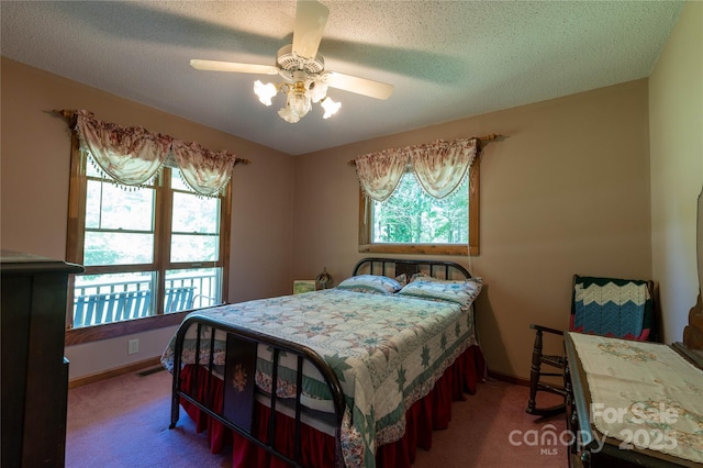 carpeted bedroom with a textured ceiling and ceiling fan