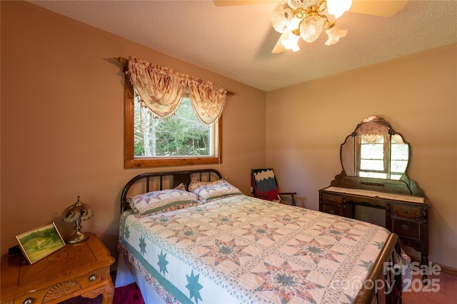 bedroom with ceiling fan and a textured ceiling