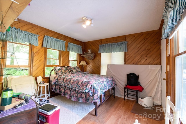 bedroom featuring wood walls and hardwood / wood-style floors