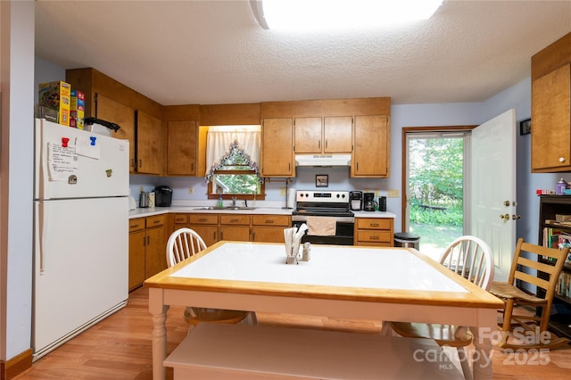 kitchen featuring sink, a textured ceiling, white refrigerator, and stainless steel electric range