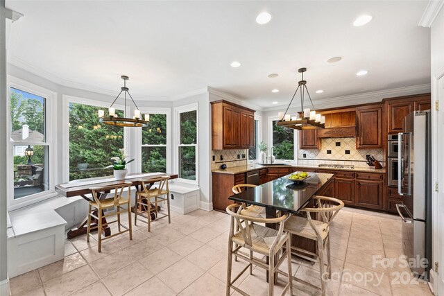 kitchen featuring a chandelier, stainless steel appliances, tasteful backsplash, and crown molding