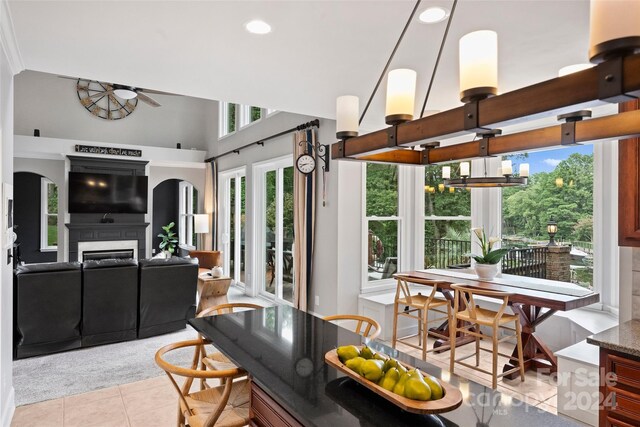 interior space with arched walkways, a fireplace, and ceiling fan with notable chandelier