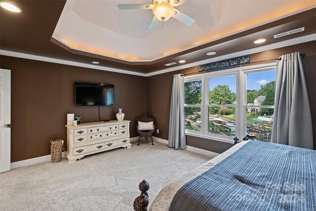 bedroom with carpet floors, a tray ceiling, crown molding, and baseboards