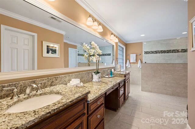 bathroom with crown molding, visible vents, and a sink