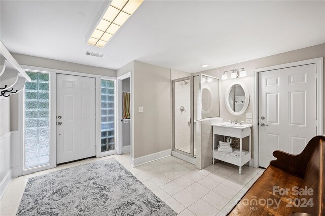 bathroom with a stall shower, baseboards, visible vents, tile patterned floors, and vanity