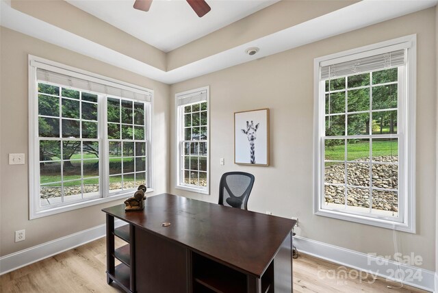 home office featuring light wood-style floors, baseboards, and a ceiling fan