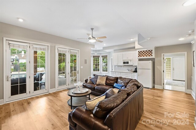 living room with a ceiling fan, recessed lighting, baseboards, and light wood finished floors