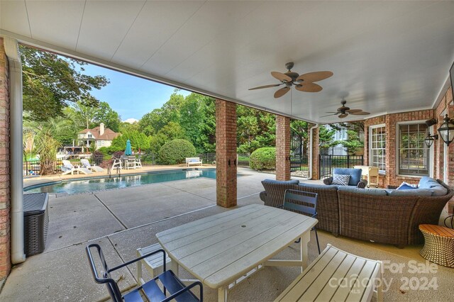 view of patio with fence, an outdoor living space, a ceiling fan, an outdoor pool, and outdoor dining space