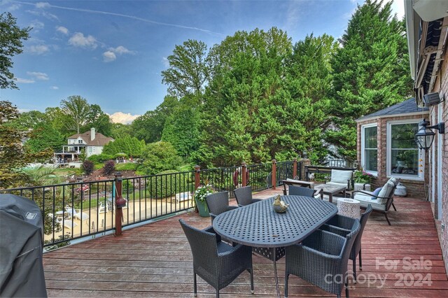 wooden deck with outdoor dining space and a grill