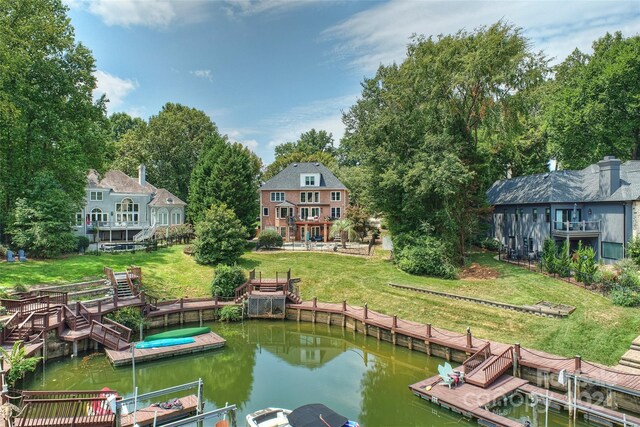 view of dock with a water view and a lawn