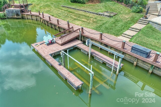 dock area with a water view and a lawn