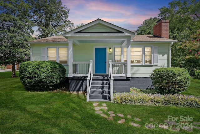 bungalow featuring a yard and covered porch