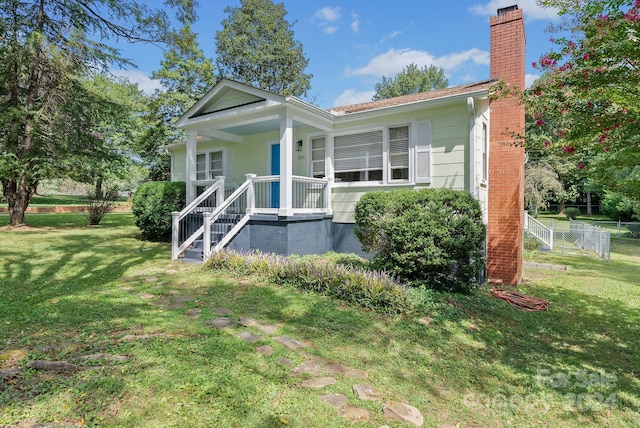 view of front of home featuring covered porch and a front yard