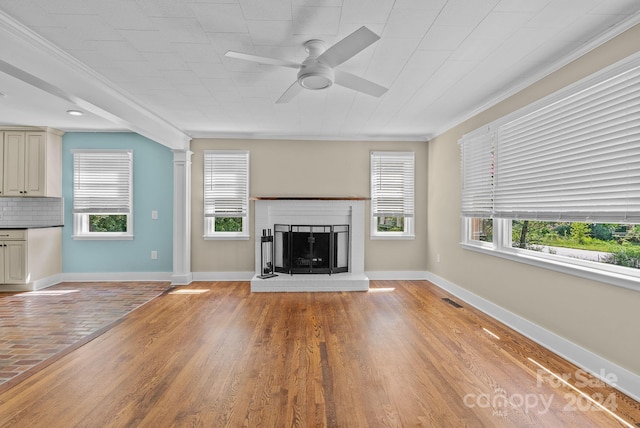 unfurnished living room featuring crown molding, a wealth of natural light, ceiling fan, and light hardwood / wood-style floors