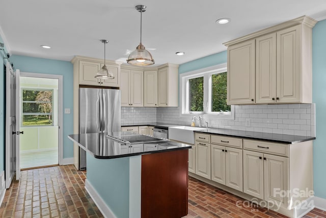 kitchen with tasteful backsplash, a center island, and cream cabinets