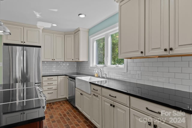 kitchen featuring backsplash, cream cabinets, appliances with stainless steel finishes, sink, and pendant lighting