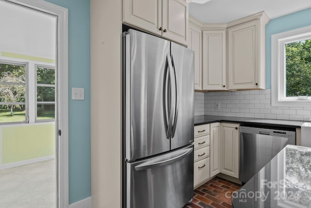 kitchen featuring cream cabinetry, appliances with stainless steel finishes, and decorative backsplash