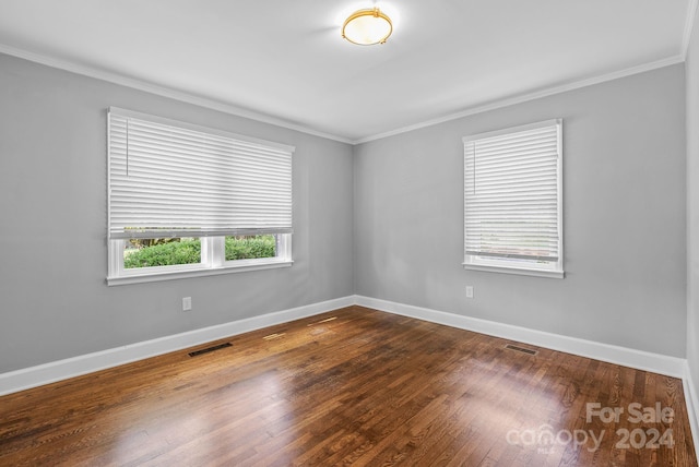 unfurnished room with ornamental molding and dark hardwood / wood-style flooring