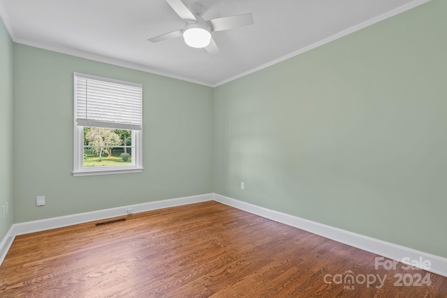 empty room featuring crown molding, dark hardwood / wood-style flooring, and ceiling fan