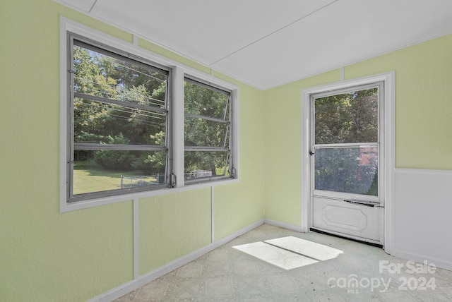 spare room with lofted ceiling and a healthy amount of sunlight