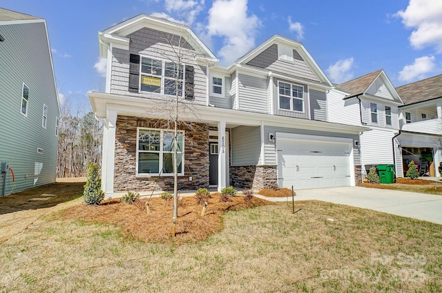 view of front facade with a front lawn, stone siding, driveway, and an attached garage