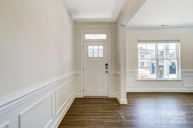 doorway to outside featuring dark wood-style floors, visible vents, a wainscoted wall, and ornamental molding