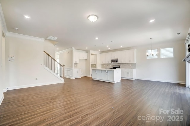 unfurnished living room featuring recessed lighting, dark wood-style flooring, baseboards, and stairs