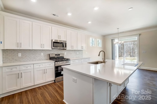 kitchen featuring a center island with sink, visible vents, white cabinets, stainless steel appliances, and a sink