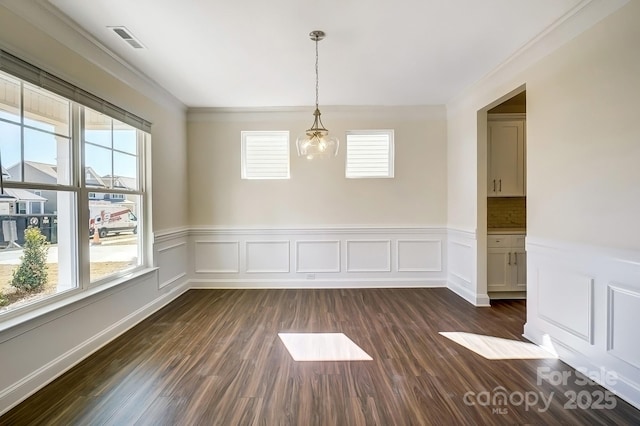 unfurnished dining area with dark wood-style floors, wainscoting, visible vents, and an inviting chandelier