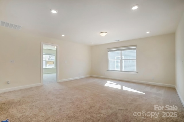 unfurnished room with recessed lighting, visible vents, light carpet, and baseboards