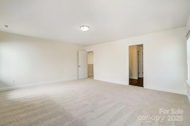 empty room featuring carpet flooring and baseboards