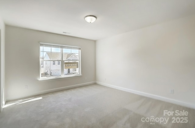 carpeted empty room with visible vents and baseboards