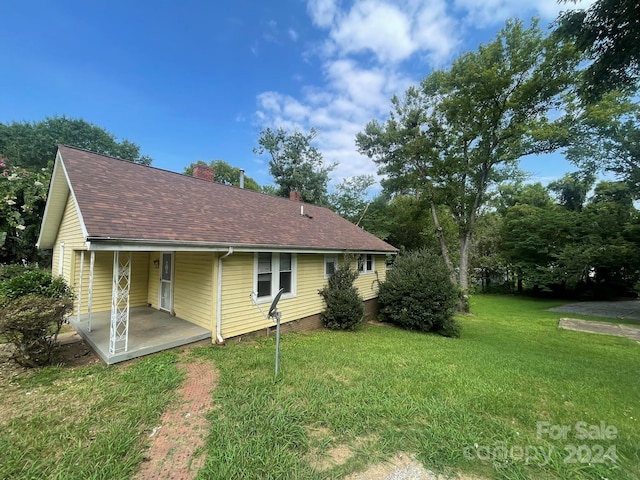 rear view of property featuring a lawn