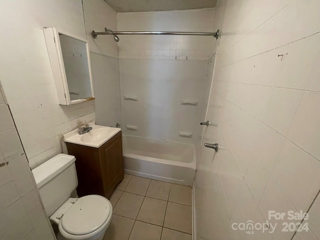 full bathroom featuring tile patterned floors, toilet, tile walls, vanity, and shower / bath combination