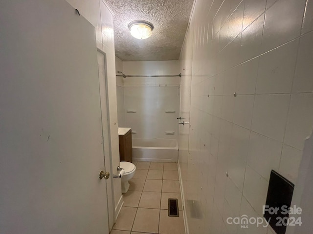 full bathroom with tile walls, vanity, toilet, tile patterned floors, and a textured ceiling