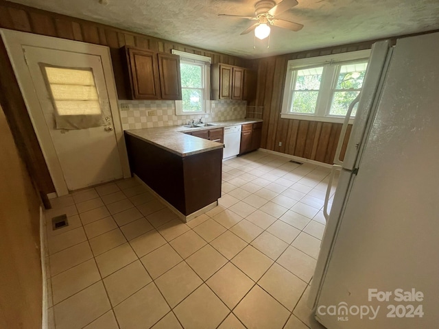 kitchen with tasteful backsplash, light tile patterned floors, a textured ceiling, and white appliances