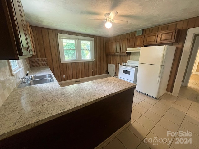 kitchen featuring sink, backsplash, light tile patterned floors, kitchen peninsula, and white appliances