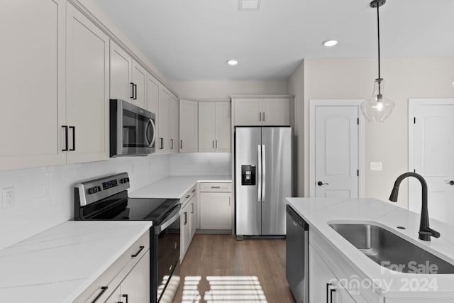 kitchen with stainless steel appliances, sink, dark hardwood / wood-style floors, white cabinetry, and hanging light fixtures