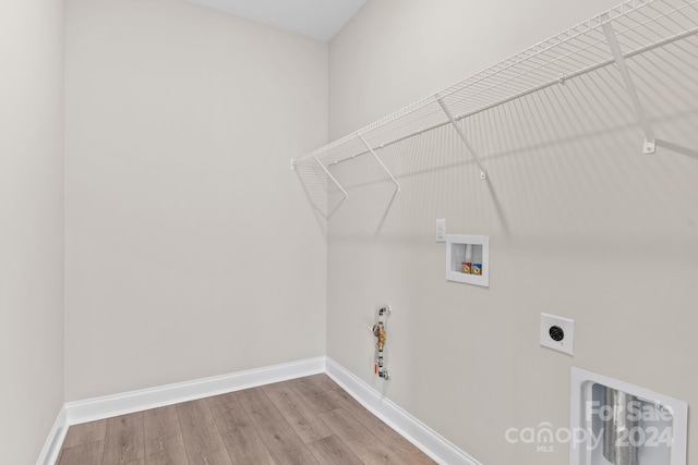 laundry room featuring electric dryer hookup, gas dryer hookup, light hardwood / wood-style flooring, and washer hookup