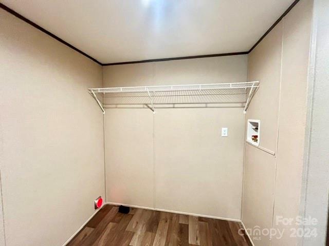 laundry area with ornamental molding, hardwood / wood-style floors, and washer hookup