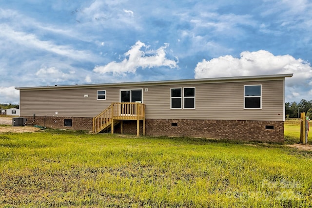 back of property with cooling unit and a lawn