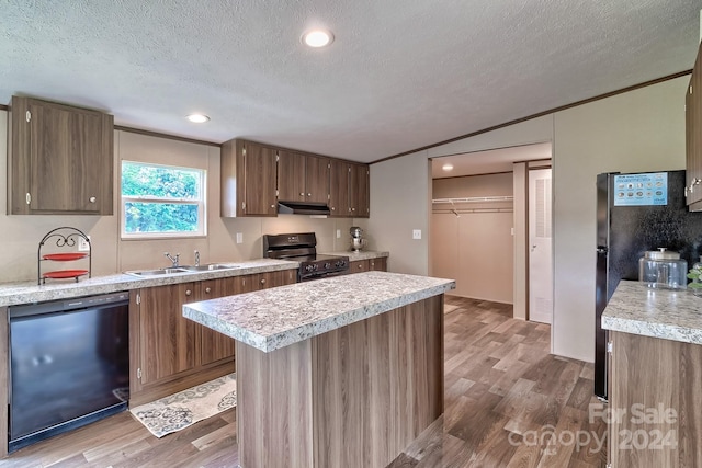 kitchen featuring a textured ceiling, light wood-type flooring, sink, and black appliances