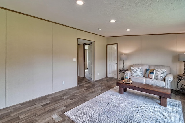 living room with ornamental molding, a textured ceiling, and hardwood / wood-style flooring