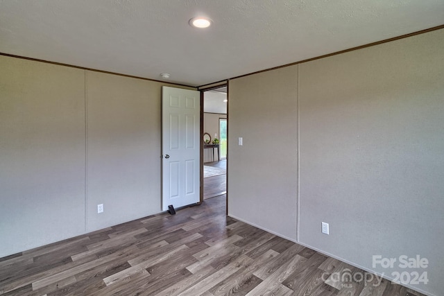 spare room featuring light wood-type flooring and ornamental molding