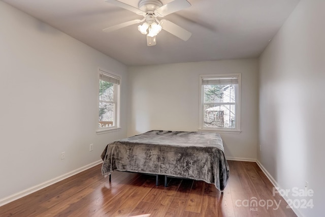 bedroom with hardwood / wood-style flooring, multiple windows, and ceiling fan