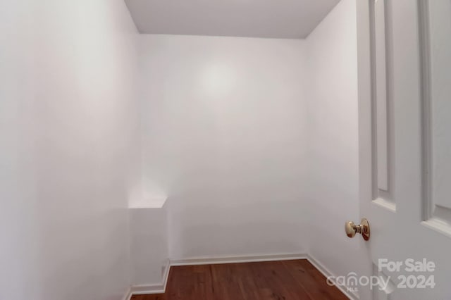 walk in closet with dark wood-type flooring