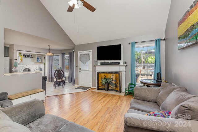 living room featuring washer and clothes dryer, ceiling fan, light hardwood / wood-style floors, and high vaulted ceiling