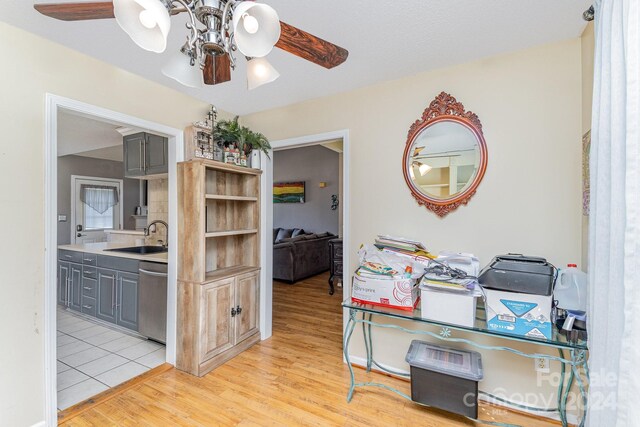 interior space with dishwasher, gray cabinets, light hardwood / wood-style flooring, and sink