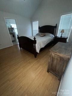 bedroom with light wood-type flooring and lofted ceiling